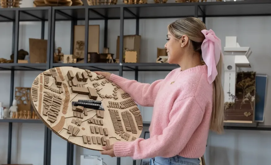 Estudiante de arquitectura admirando un maquetado de urbanismo sostenible