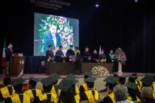 Alumnos recibiendo sus documentos en ceremonia de graduación.